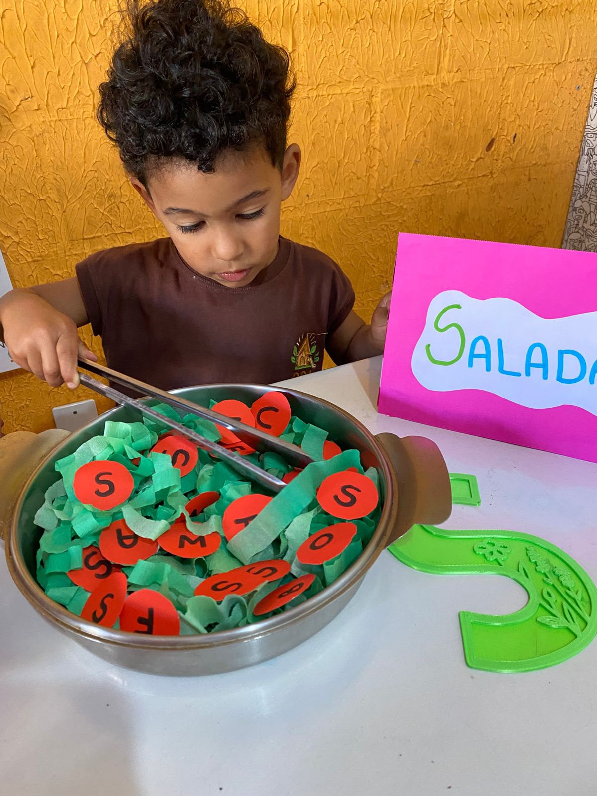 Criança em atividade de letras no Maternal da OCA